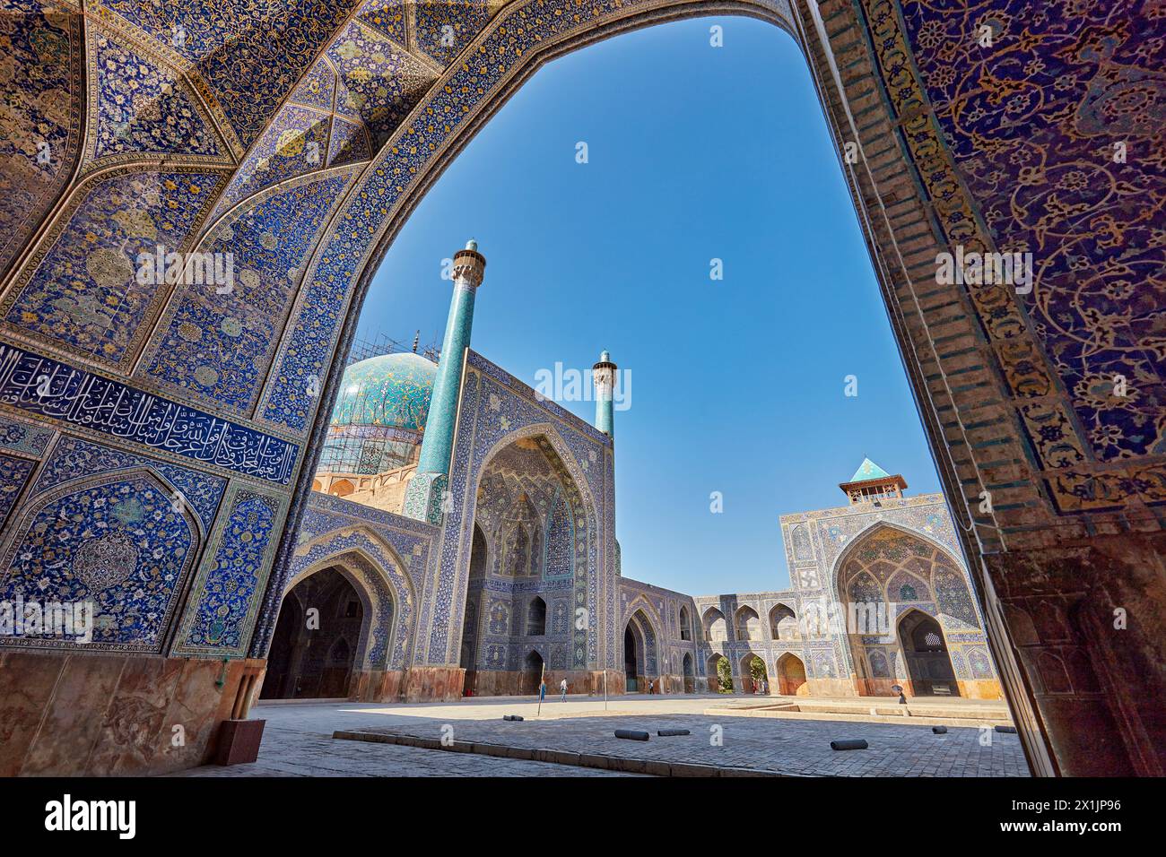 Blick auf den Innenhof der Shah Moschee (Masjed-e Shah) durch einen Bogen mit aufwendigen Fliesen. Isfahan, Iran. Stockfoto