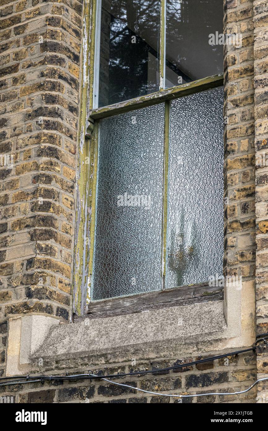 Der Schatten eines Kandelabers durch ein Milchglasfenster in einem alten Haus in London, Großbritannien Stockfoto