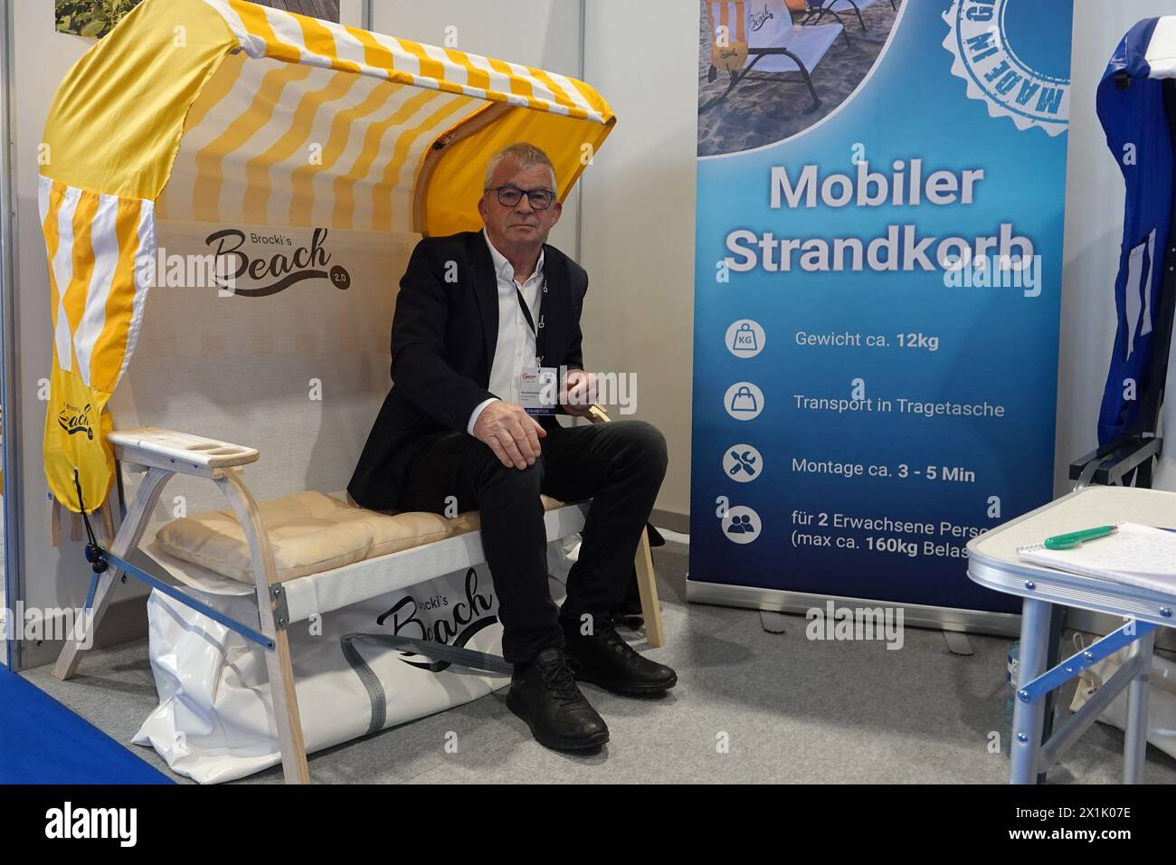 Genf, Schweiz. April 2024. Ronald Brockmann sitzt in seinem mobilen Liegestuhl. (Zu dpa 'der mobile Strandstuhl und andere Ideen auf der Genfer Erfindermesse') Credit: Christiane Oelrich/dpa/Alamy Live News Stockfoto