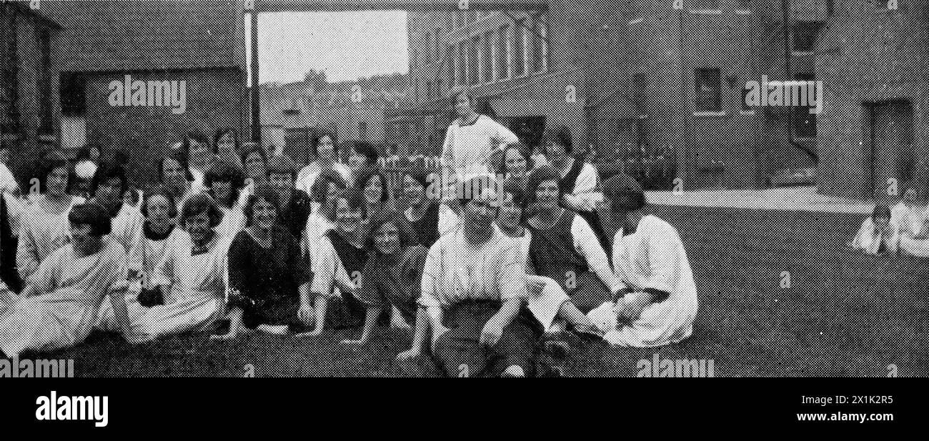 Die Dinner-Stunde. Das Personal sitzt auf dem Gras auf dem Gelände der Fabrik Nr. 4 in Bristol. Mit Sitz in Bristol, England, war W. D. und H. O. Wills einer der größten britischen Tabakhersteller. 1924 waren sie Teil der Imperial Tobacco Group in Großbritannien und Irland, hatten aber noch eine gewisse Autonomie. Das Unternehmen war auch ein produktiver Verleger von Zigarettenkarten. Stockfoto