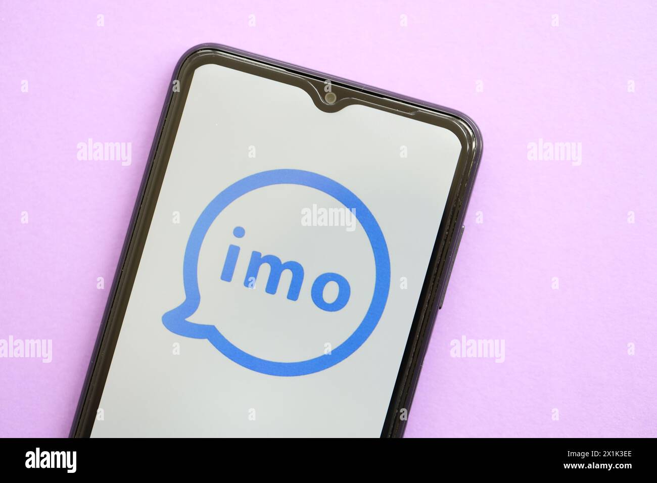 KIEW, UKRAINE - 1. APRIL 2024 IMO Messenger-Symbol auf Smartphone-Bildschirm auf lila Tisch Nahaufnahme. IPhone-Display mit App-Logo auf lilafarbenem Hintergrund Stockfoto