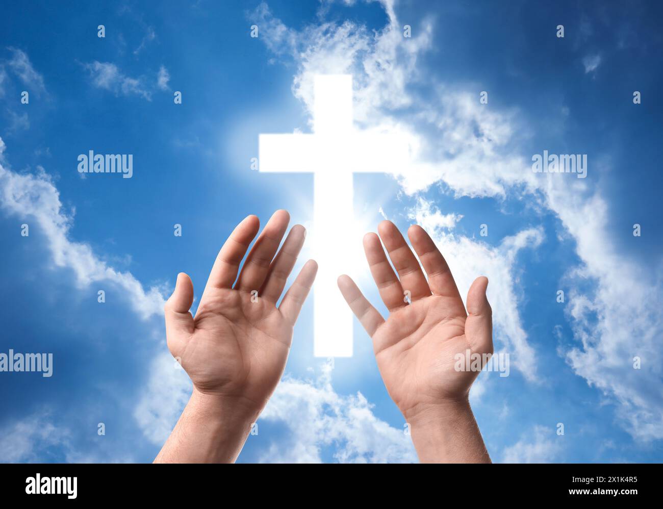 Religion. Christlicher Mann betet gegen den Himmel mit glühendem Kreuz, Nahaufnahme Stockfoto