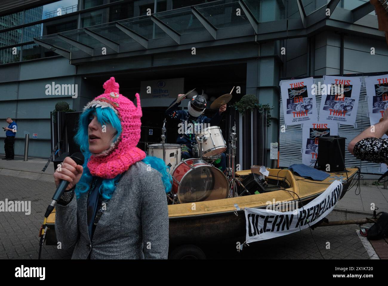 Ocean Rebellion (OR) veranstaltet ein Protestkonzert gegen einen Bergbaugipfel im Hilton in Canary Wharf, in dem seine schädlichen Auswirkungen auf die Meereslebewesen hervorgehoben werden. Der Tiefseebergbau, bei dem „Manganknollen“ aus dem Meeresboden für die Verwendung in grünen Technologien gewonnen werden, verursacht vermutlich erhebliche Umweltschäden. Sie entzieht dem Meeresboden Leben, setzt Sedimentfedern frei und erzeugt Geräusche, die Meerestiere verwirren. Die Lärmbelästigung durch den Tiefseebergbau ist hundertmal lauter als ein Raketenstart. Eine Tiefsee-Bergbaulizenz würde einen Meeresboden um ein Drittel der Größe Belgiens abreißen Stockfoto