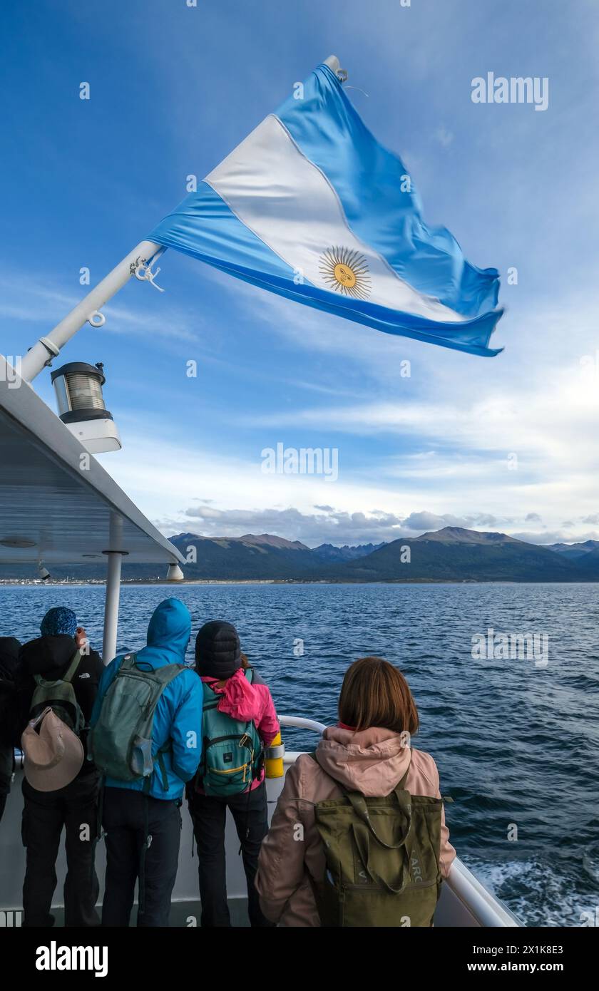 Ushuaia, Tierra del Fuego, Argentinien - Touristen auf einem Ausflugsboot unter argentinischer Flagge im Beagle-Kanal, der Beagle-Kanal ist eine natürliche Wasserstraße Stockfoto