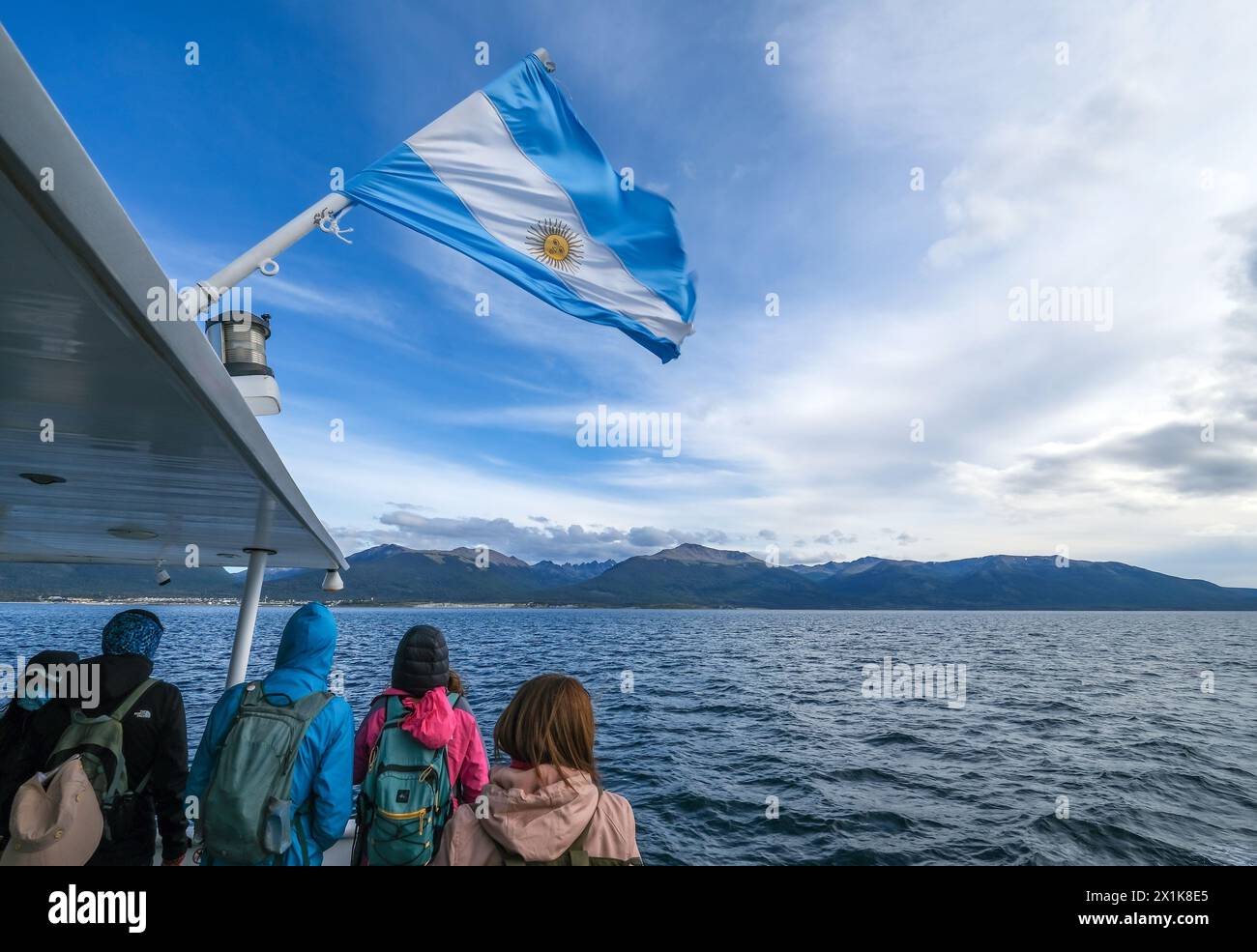 Ushuaia, Tierra del Fuego, Argentinien - Touristen auf einem Ausflugsboot unter argentinischer Flagge im Beagle-Kanal, der Beagle-Kanal ist eine natürliche Wasserstraße Stockfoto