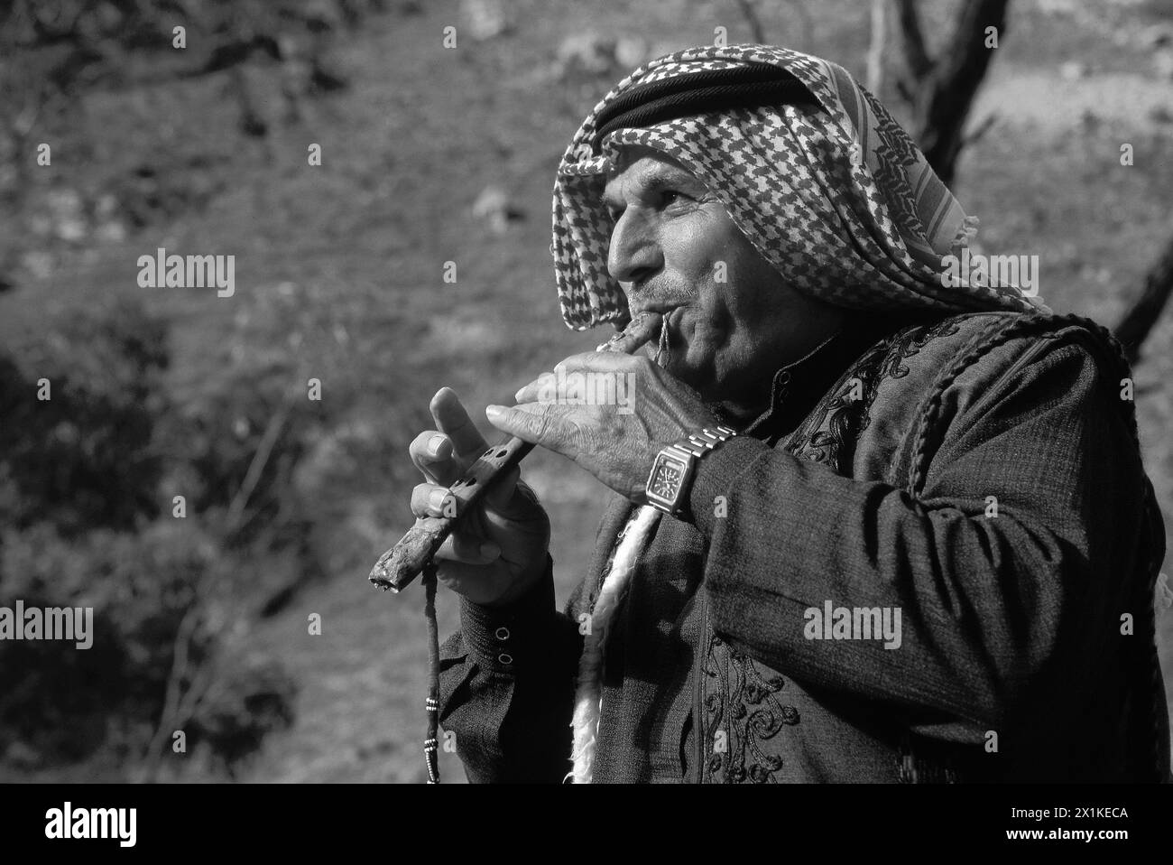 Ein älterer Beduin spielt eine traditionelle Flöte aus Geierknochen Stockfoto