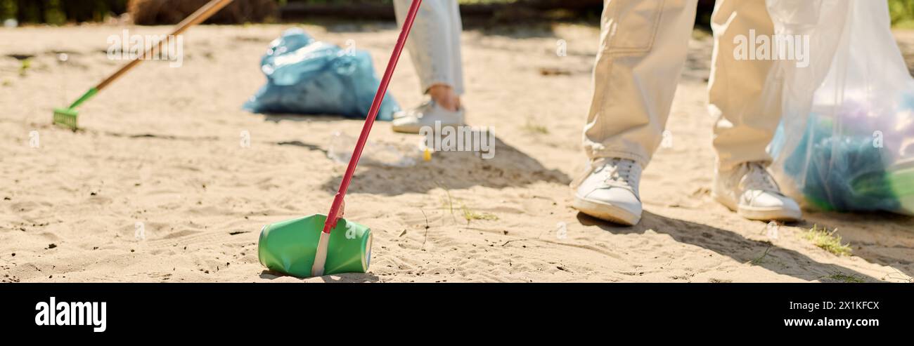 Multirassisch liebendes Paar, das leidenschaftlich einen Park aufräumt, während es Sicherheitshandschuhe trägt. Stockfoto