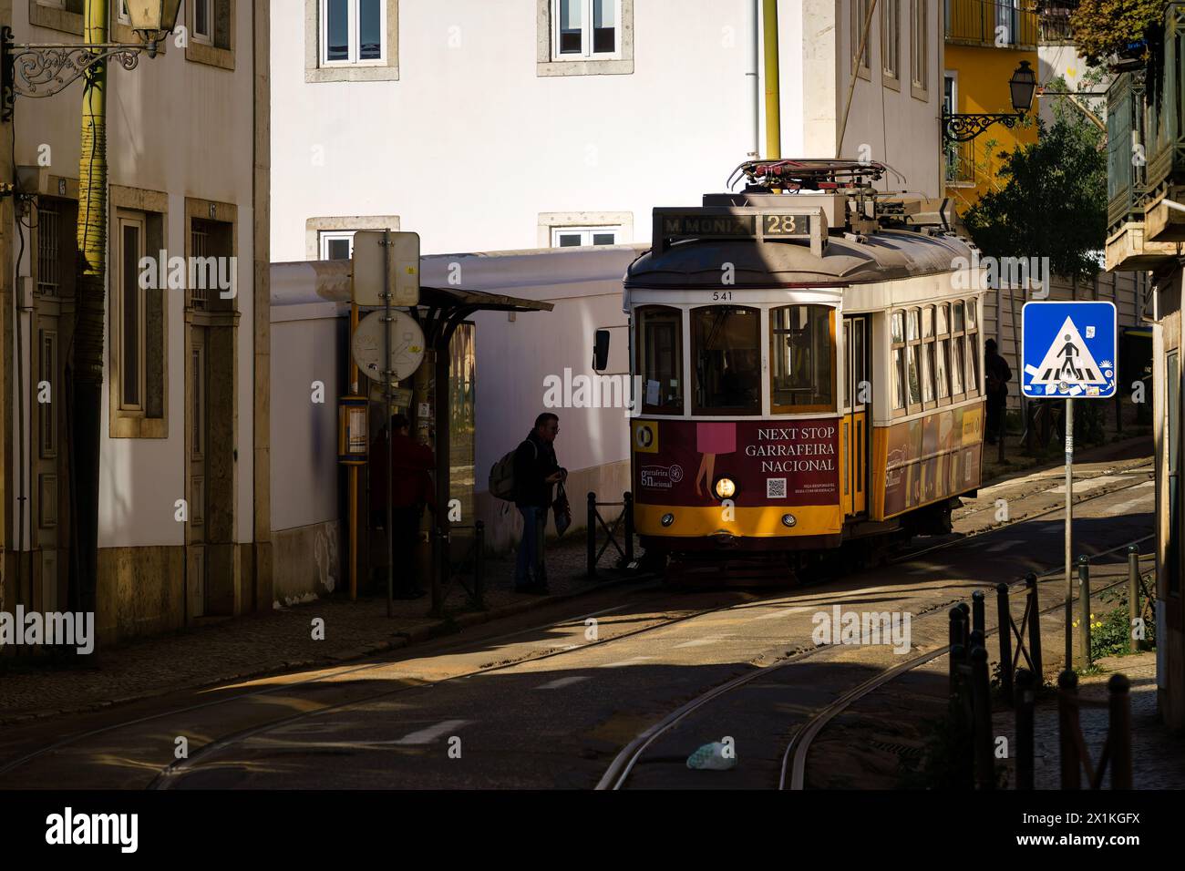 Straßenbahn 28 an der Straßenbahnhaltestelle auf der Straße Rua das Escolas Gerais in Lissabon, Portugal. Februar 2024. Stockfoto