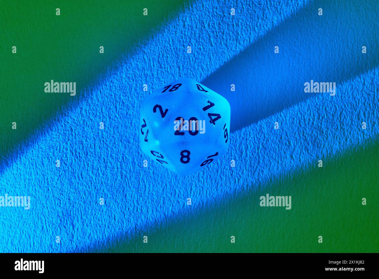 Leuchtende 20-seitige Matrize auf farbigem Hintergrund, Top-Down-Ansicht Stockfoto