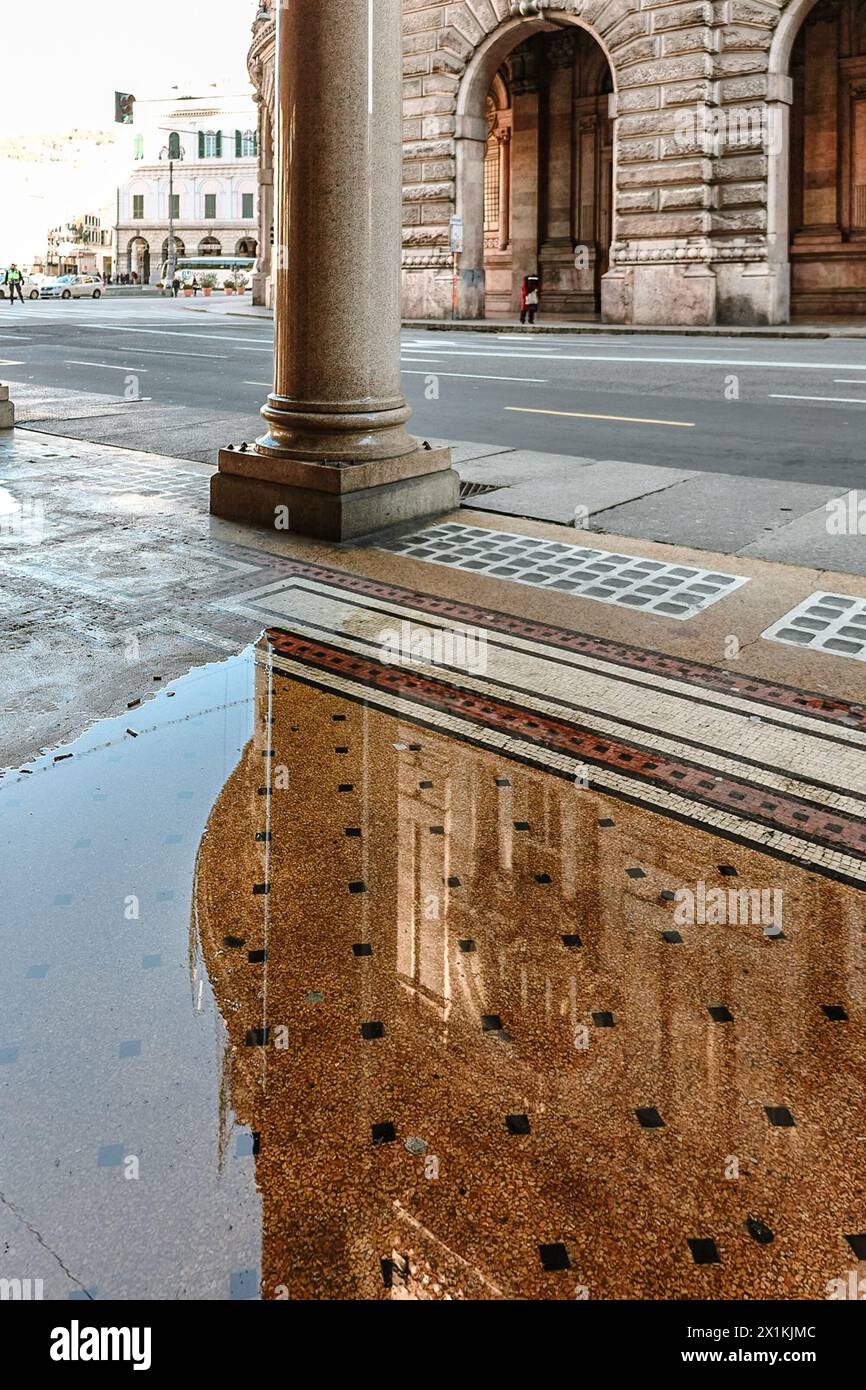 Galerie mit Bögen mit Säulen im Gebäude der Stadtverwaltung auf dem Ferrari-Platz in wunderschönem Sonnenuntergangslicht mit Reflexion im Wasser. Palazzo della Regione Liguria in Genua, Ligurien, Italien Stockfoto