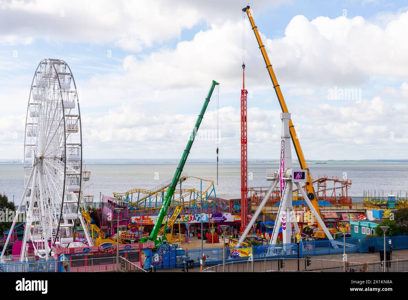 Kräne vor Ort im Vergnügungspark Adventure Island heben den neuen Vertigo 38 Meter Tower Ride in Position. Fallturm Stockfoto