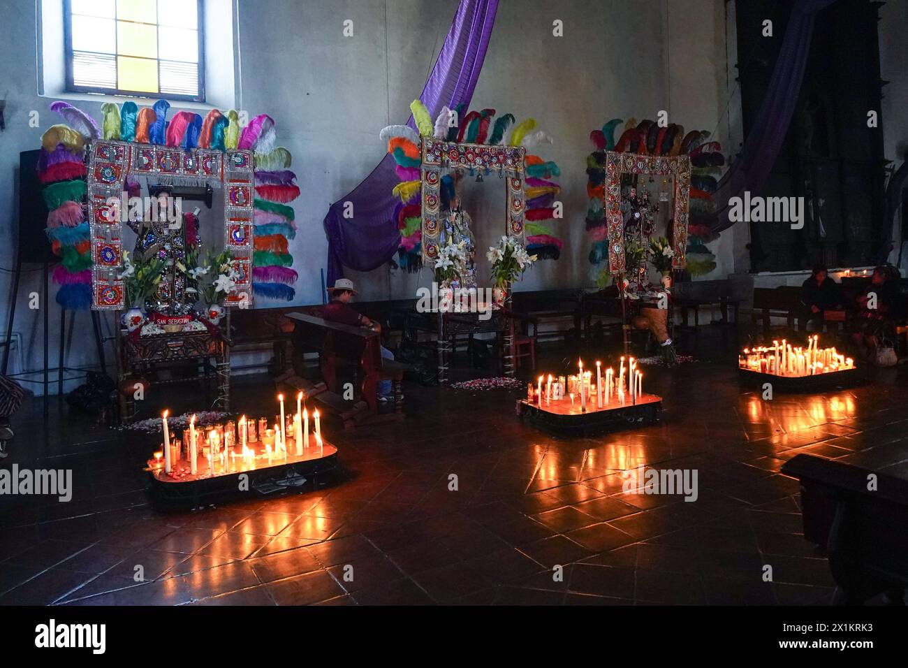 Maya-Altarplattformen, auf denen Kerzen und Kopal-Weihrauch durch Statuen von Heiligen in der katholischen Kirche Inglesia de Santo Tomas aus dem 15. Jahrhundert in Chichicastenango, Guatemala, verbrannt werden. Die katholische Kirche und die Maya-Glaubenssätze haben sich vor langer Zeit in den indigenen Regionen Guatemalas in einem Prozess gemischt, der Synkretismus genannt wird. Stockfoto