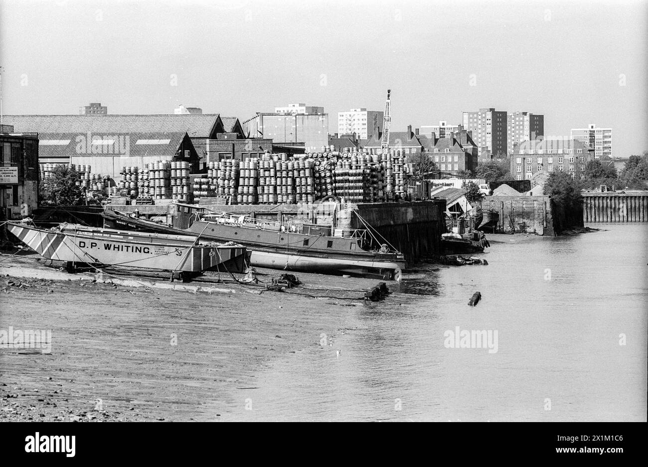 Archivbild der Südseite der Themse aus den 1990er Jahren, westlich von Greenwich aus gesehen. Das Boot in der mittleren Distanz ist die Massey Shaw, vor der Restaurierung. Massey Shaw wurde 1935 auf der Isle of Wight nach einem LCC-Entwurf für den Einsatz als Feuerwehrboot der Londoner Feuerwehr gebaut. Während des Zweiten Weltkriegs unternahm das Boot drei Fahrten im Rahmen der Evakuierung von Dünkirchen und kehrte dann während des Blitz als Feuerwehrboot auf der Themse zurück. Sie wurde 1971 außer Dienst gestellt und erhielt 2008 einen Heritage Lottery Grant zur Restaurierung. Das Boot ist heute als Attraktion im South Dock der West India Docks angelegt. Stockfoto