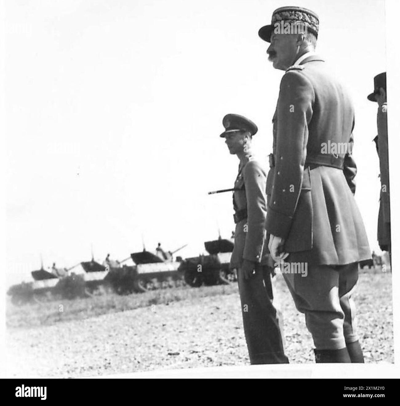 Seine Majestät der König beobachtet zusammen mit den Generälen Giraud und de Gaulle französische Panzereinheiten, die mit amerikanischen Sherman-Panzern ausgerüstet sind, während einer Militärparade, die internationale militärische Zusammenarbeit zeigt. Stockfoto