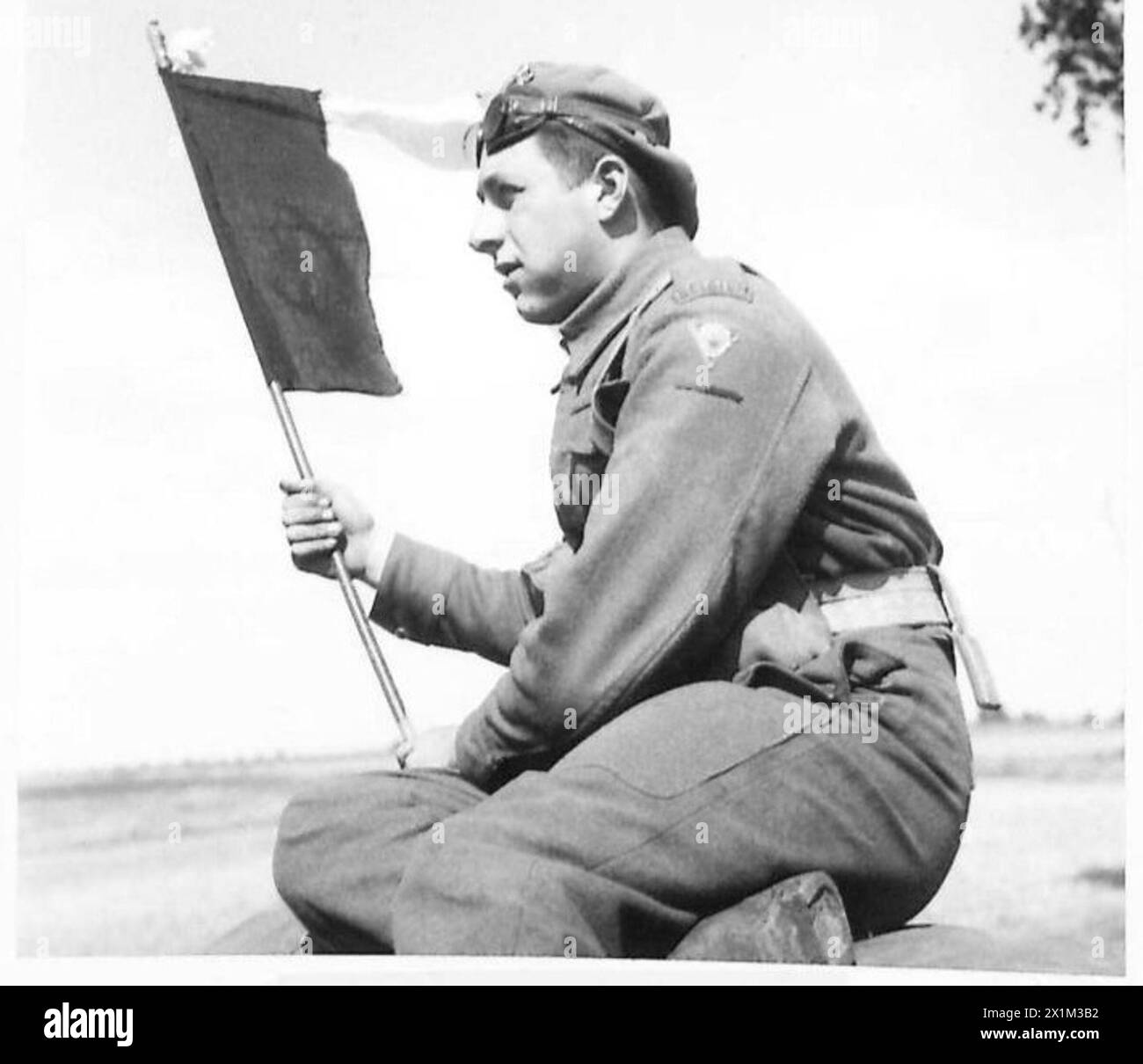 Ein belgischer Soldat setzt seine Nationalflagge auf, bevor er die französisch-belgische Grenze bei Operationen in Nordwesteuropa (1944–1946) mit der 21. Armeegruppe der britischen Armee überquert. Stockfoto