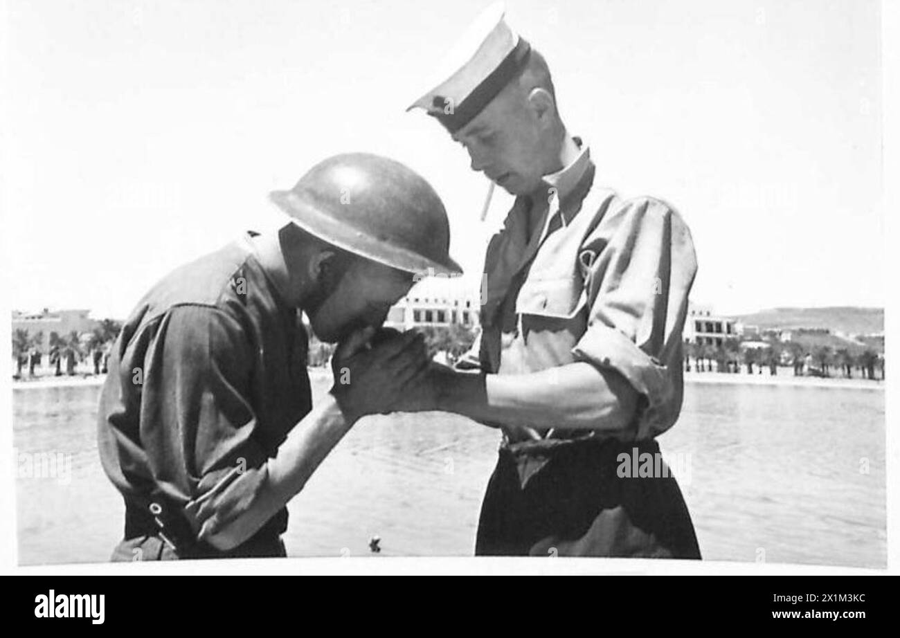 Die alliierten Flotten der Marine legen im Hafen von Bizerta an, während die britische Armee während des Zweiten Weltkriegs an Land interagiert. Stockfoto