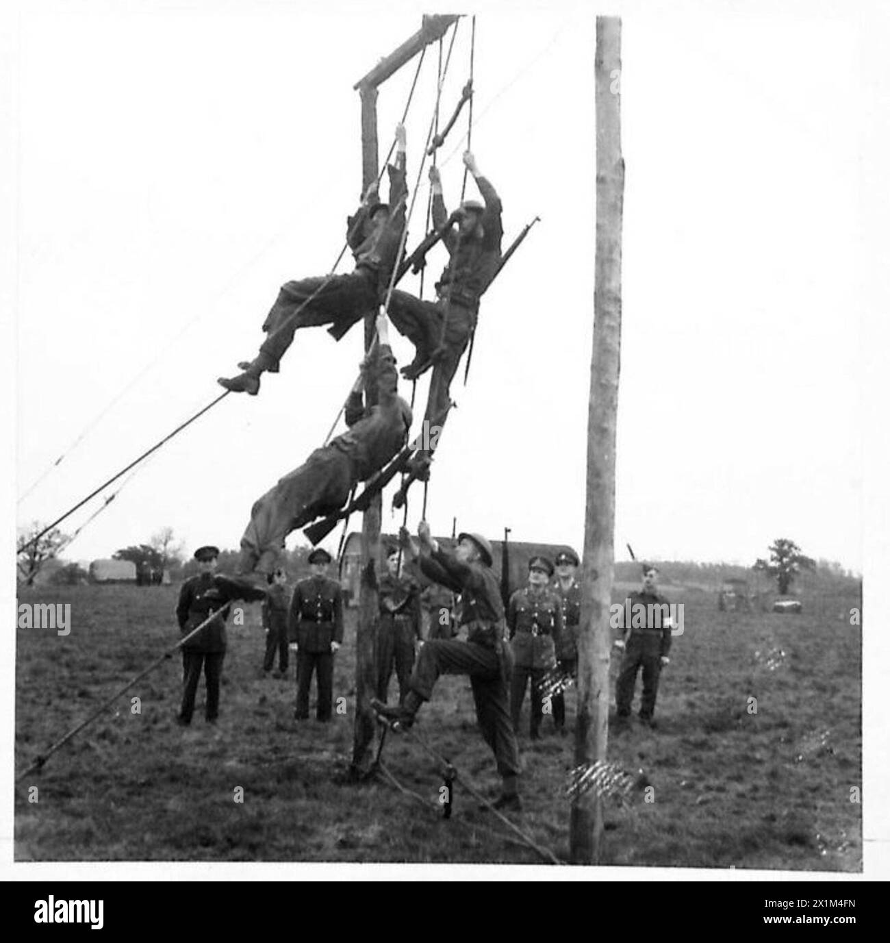 DER DIREKTOR FÜR MASCHINENBAU BESUCHT DIE R.E.M.E. BATAILLON-AUSBILDUNGSSCHULE [EPPING FOREST] - Truppenseilklettern auf dem Sturmkurs, British Army Stockfoto