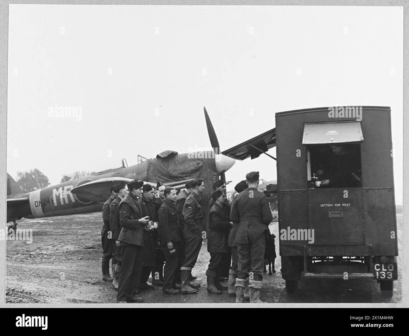 Bodenbesatzungen der Northern Rhodesian Squadron werden während einer Morgenpause im Jahr 1944 gezeigt. Das Personal steht für Tee und Erfrischungen an und erledigt tägliche Routineaufgaben auf einer Basis der Royal Air Force. Stockfoto