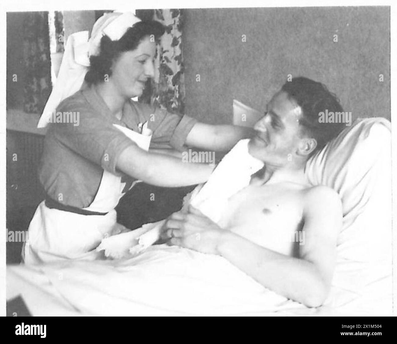 A.C.1 Mochrie von der RAF erhält persönliche Betreuung von einer dort ansässigen Roten Kreuz-Krankenschwester als Teil der britischen Roten Kreuz- und St. John-Kriegsorganisation, British Army. Stockfoto