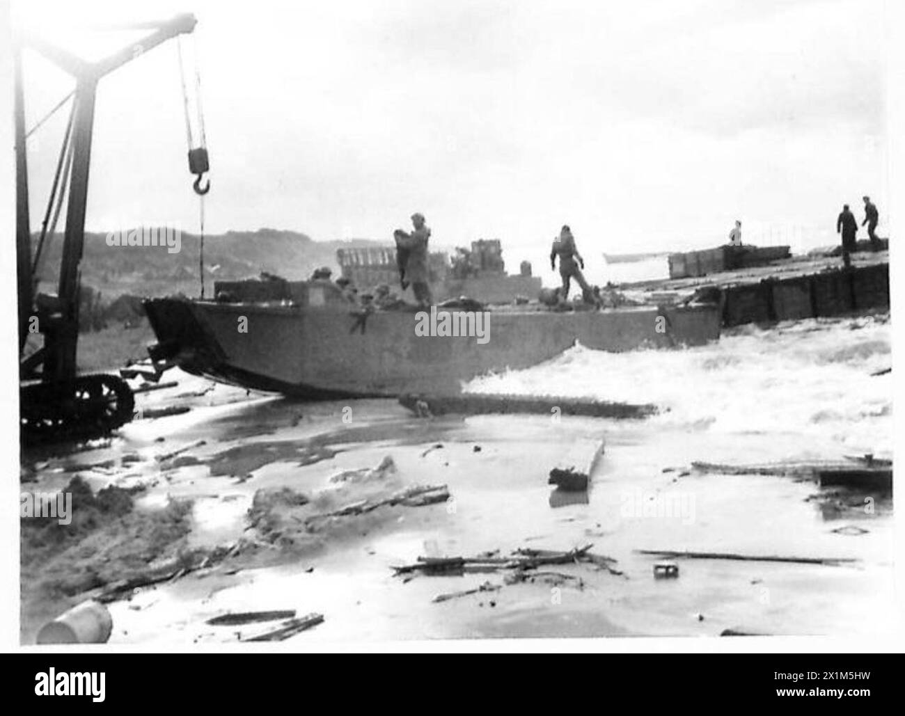 Eine allgemeine Ansicht zeigt den Strand südlich von Rom mit einem Mobilkran während alliierter Landungsoperationen unter Aufsicht der britischen Armee. Stockfoto
