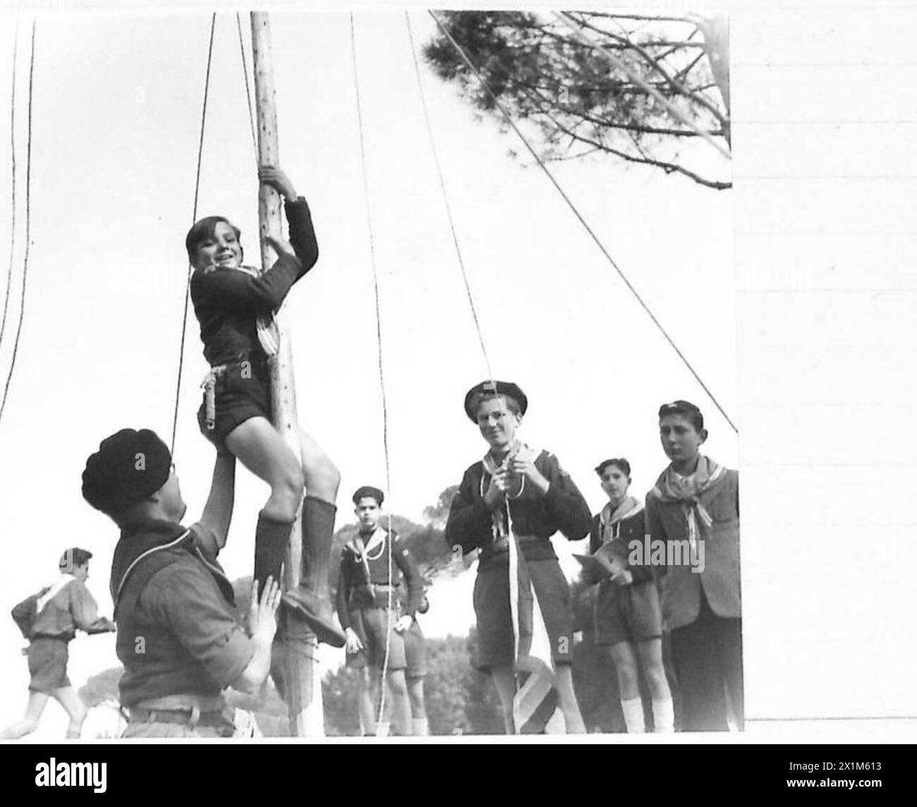 Während einer Pfadfinderkundgebung in Rom unterstützt Charlie einen jungen Sea Scout beim Klettern auf dem Fahnenmast und zeigt Jugendliche Aktivitäten und Ausbildung unter Aufsicht der britischen Armee. Stockfoto