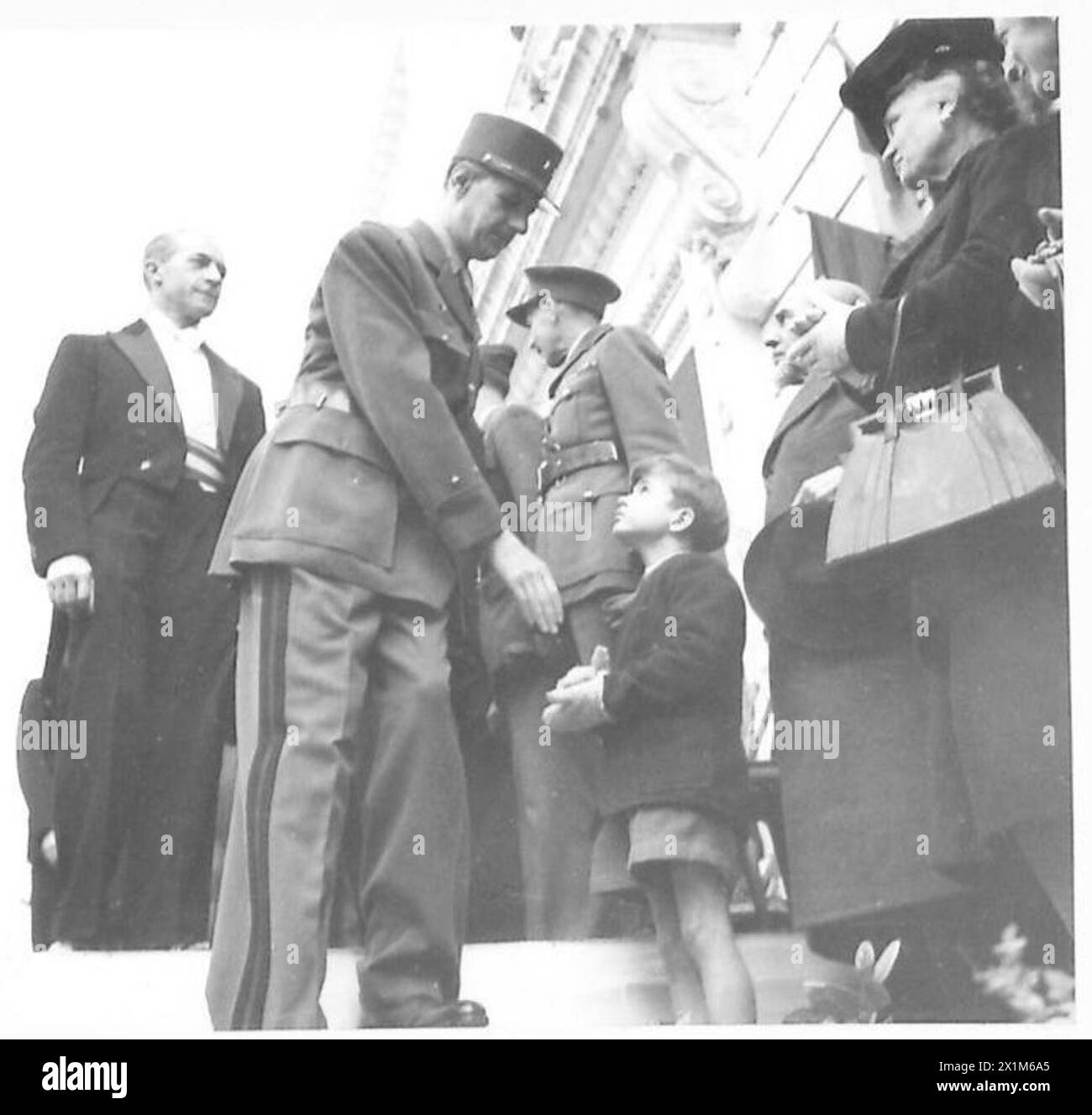 General de Gaulle schüttelte einem jungen Zuschauer die Hand, nachdem er einen französischen Helden in Nordafrika geehrt hatte. Stockfoto