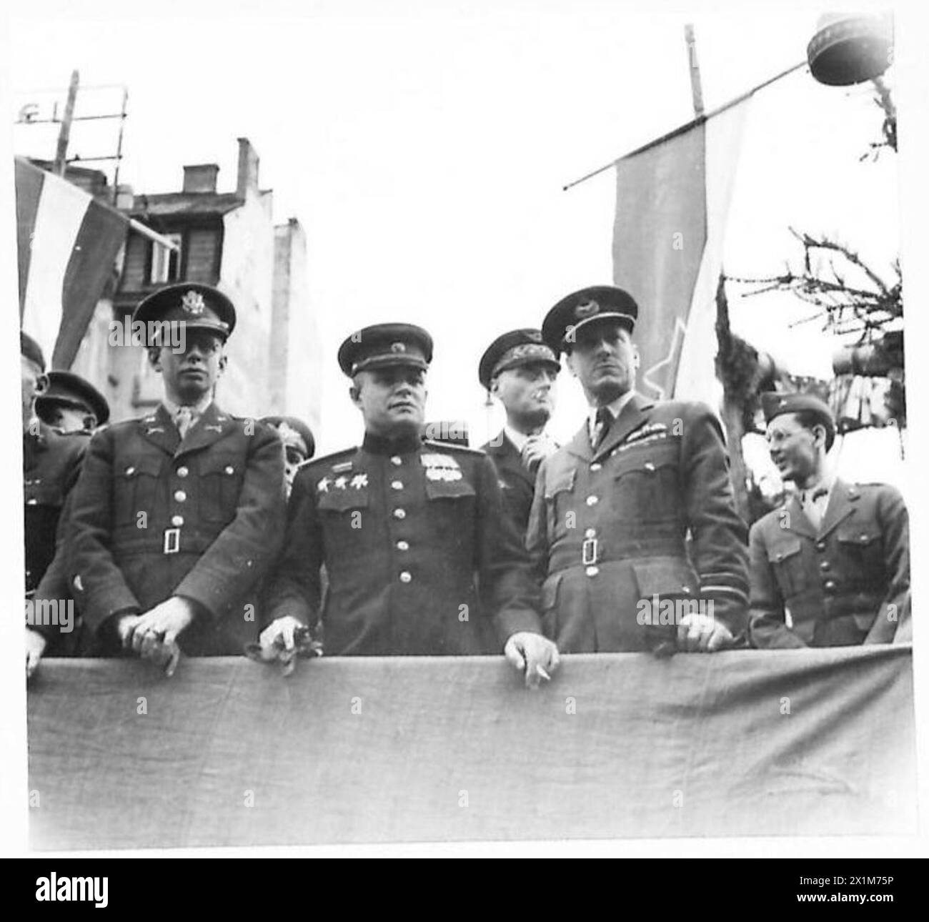 Jugoslawien feiert den 27. März mit einer Partisanenparade. Oberst Thayer, General Kisilev und Air-Vize Marschall B.M. Lee beobachten von der Saluingbasis aus die amerikanischen, russischen und britischen Missionen. Stockfoto