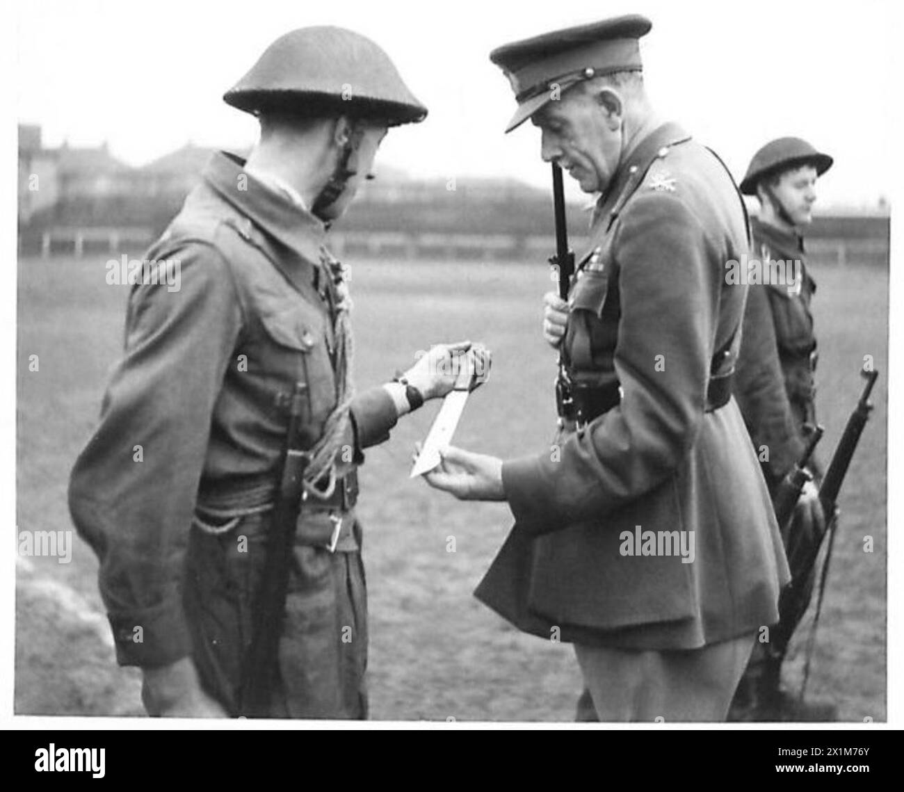 Major General Johnson inspiziert ein hausgemachtes Kampfmesser während eines Besuchs der Glasgow Home Guard Fighting School, British Army. Stockfoto