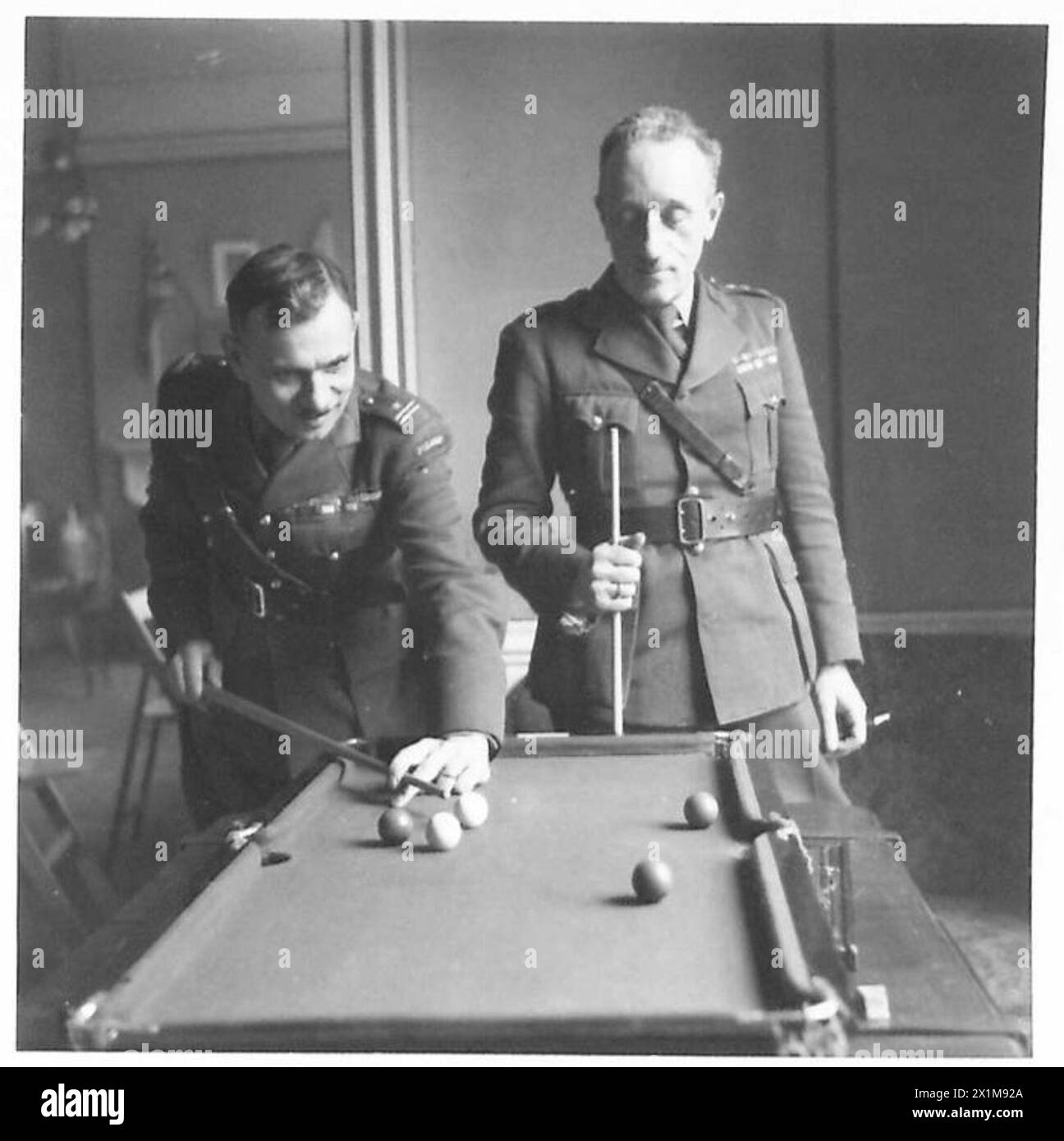 DIE POLNISCHE ARMEE IN GROSSBRITANNIEN, 1940-47 - Oberoffiziere der Brigade spielen Billard auf einem Miniaturtisch im Chaos. Foto aufgenommen in Cupar. Der Offizier auf der linken Seite ist wahrscheinlich Major Jan Olimpiusz Kamiński. Eine spezielle Fotoserie, die sich mit dem häuslichen und sozialen Leben der Truppen der 1st Rifle Brigade (1st Polish Corps) in Schottland befasst, wo die Offiziere und Männer fest etablierte Favoriten der lokalen Bevölkerung sind. Einige der jungen Soldaten besuchten Universitäten in Polen, als der Krieg ausbrach. Nach ihrer Ankunft in Großbritannien traten sie den polnischen Streitkräften bei und setzten ihre Studien bei fort Stockfoto