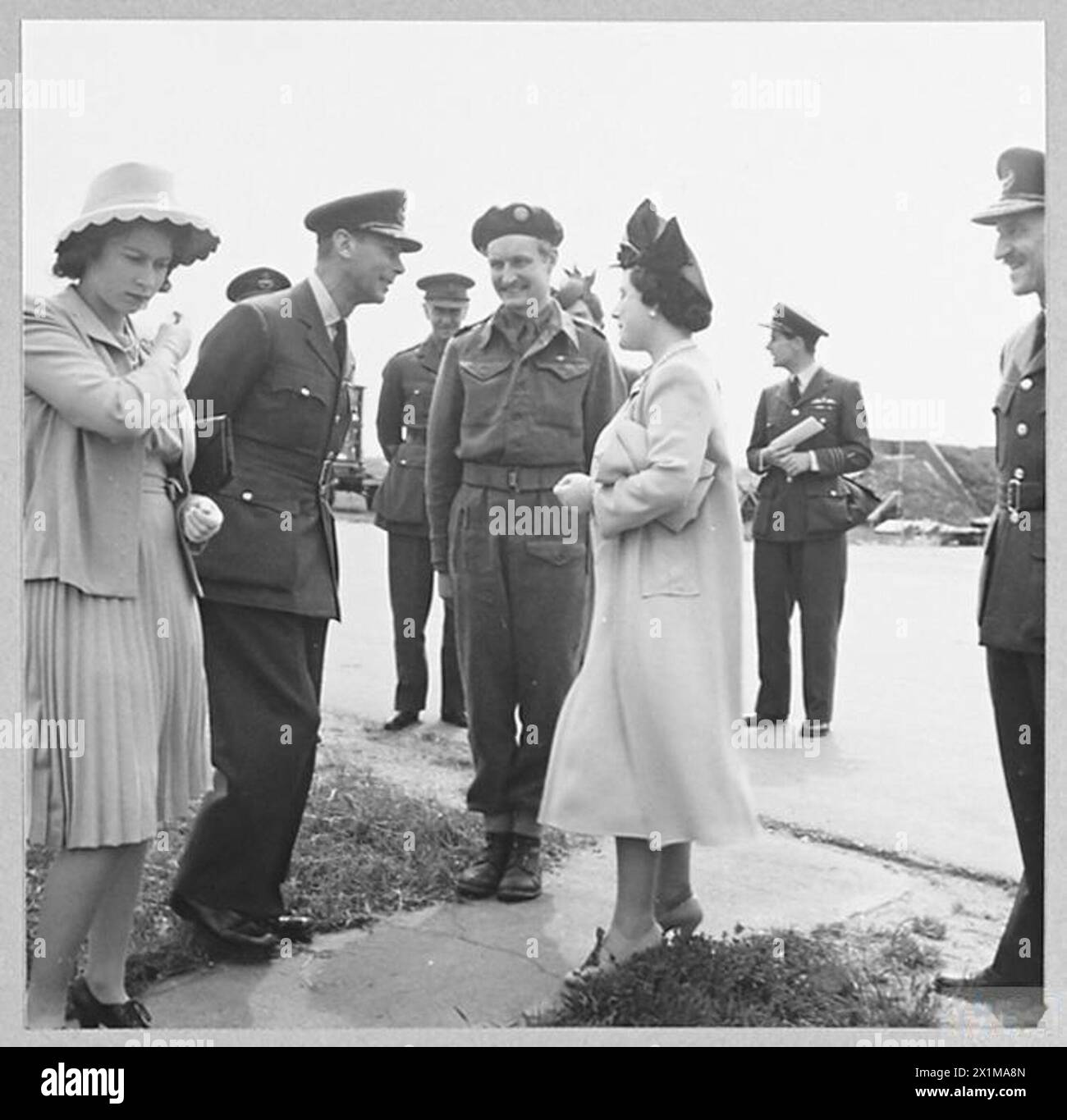 Der König und die Königin treffen den Kriegskorrespondenten Guy Byam, der am D-Day während eines königlichen Besuchs 1944 in einer Flugzeugdivision diente. Stockfoto