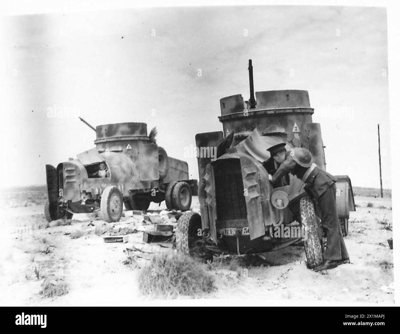 DIE LIBYSCHE KAMPAGNE - italienische gepanzerte Autos, die außer dienst gestellt wurden, am Straßenrand der britischen Armee Stockfoto