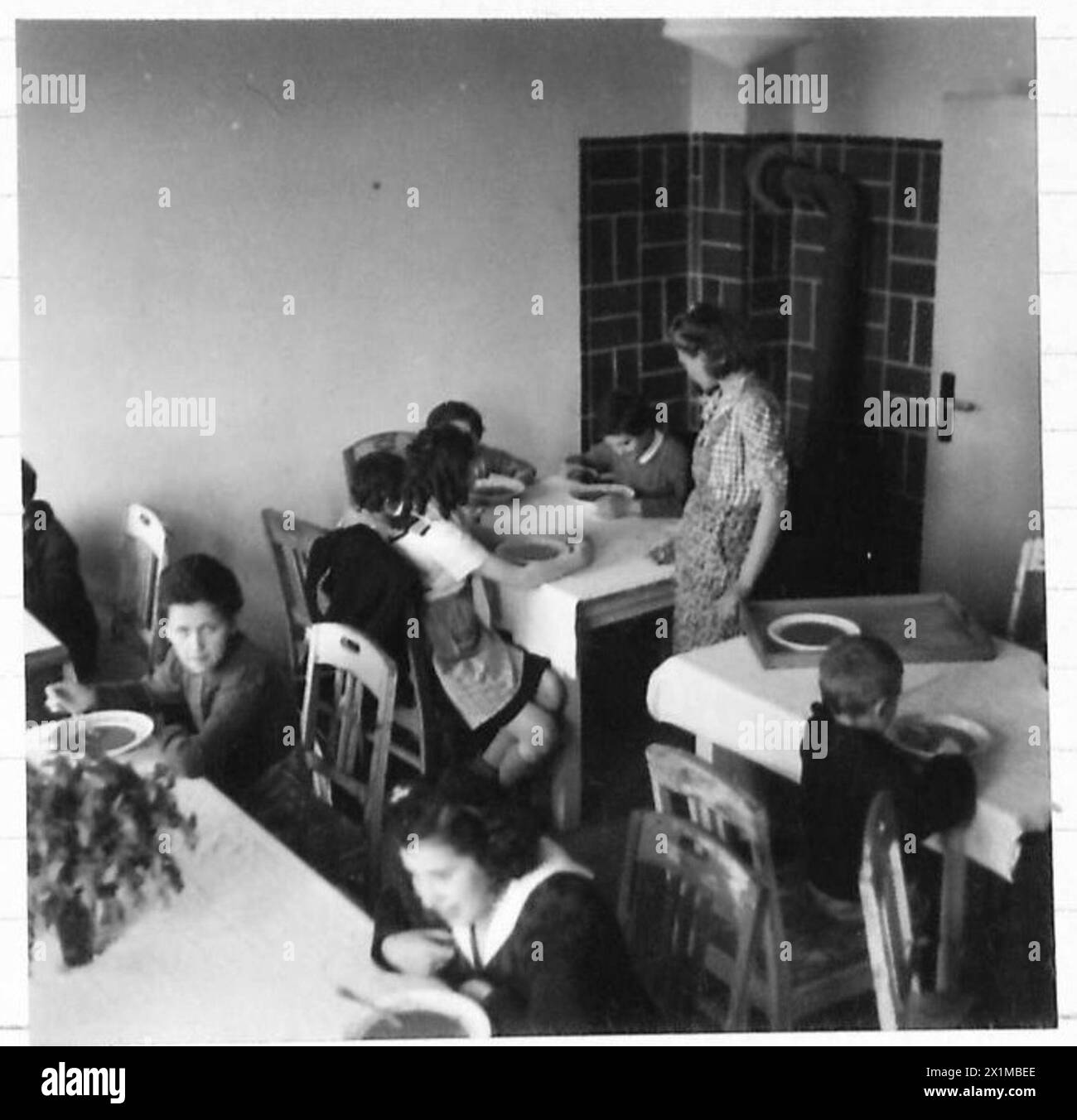 Polnische, niederländische, französische und ungarische Kinder im Lager Bergen-Belsen Nr. 2, heute Krankenhaus und Evakuierungszentrum, werden im April 1945 mittags in sauberen Speisesälen serviert. Die meisten Kinder sind jüdisch oder jüdischer Herkunft. Stockfoto