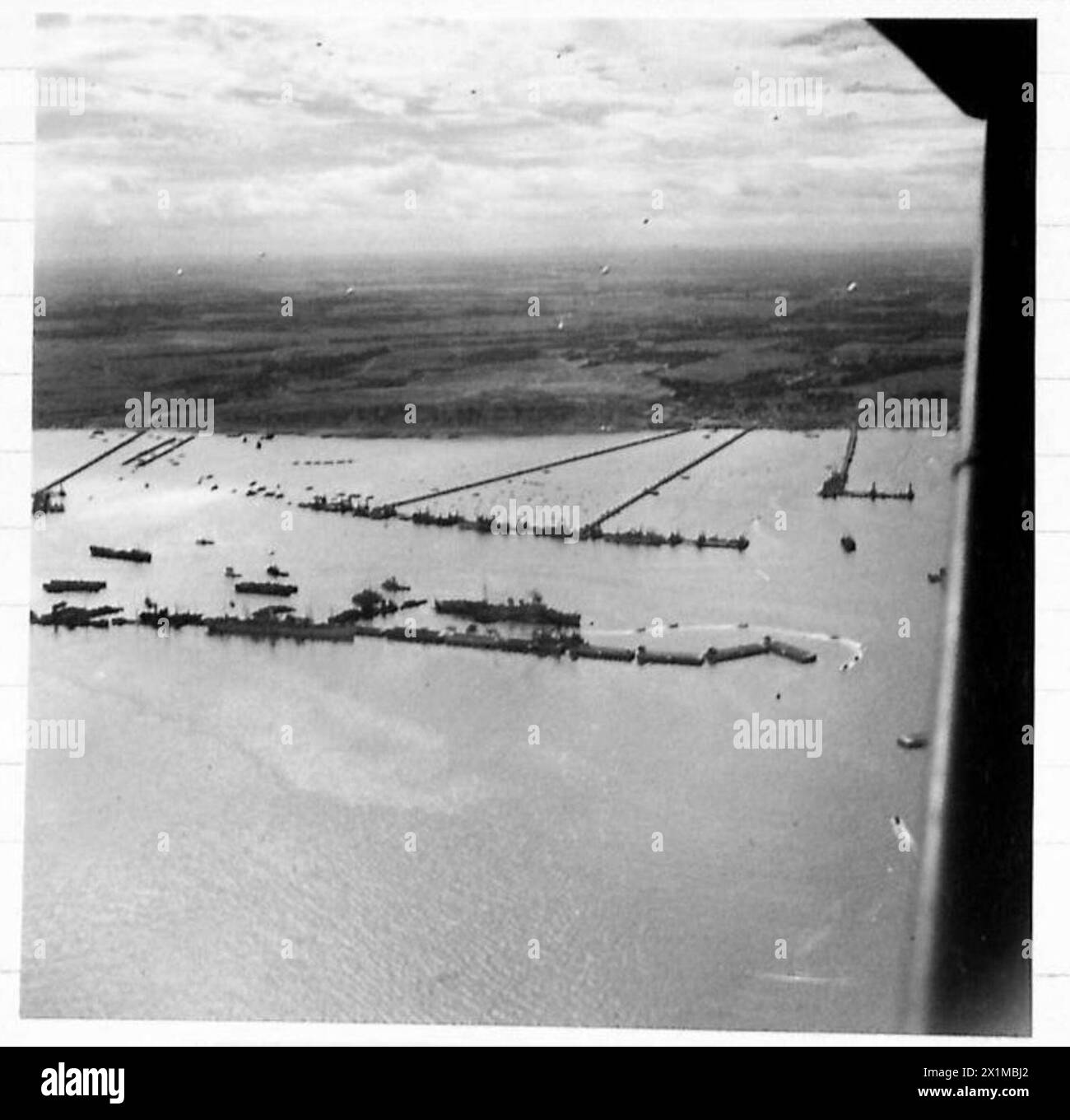 Luftaufnahmen erfassen den Hafen von Mulberry B in Arromanches und veranschaulichen die Logistik- und Ingenieuroperationen der britischen Armee in Nordwesteuropa von 1944 bis 1946. Stockfoto