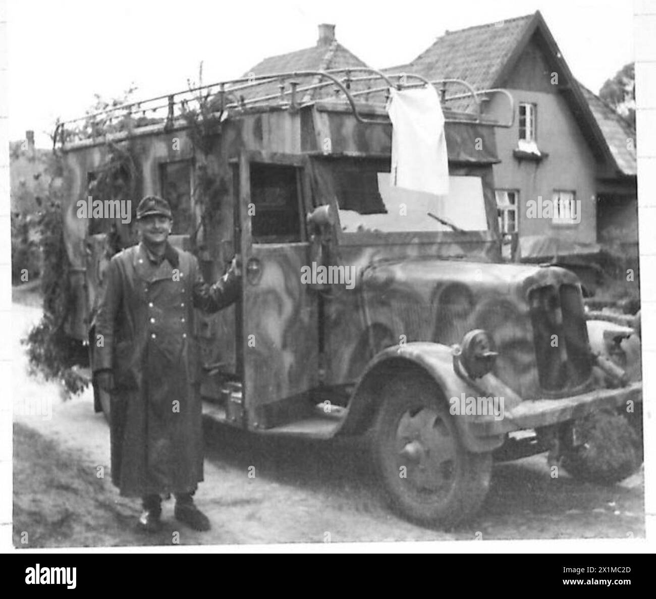 Ein Soldat, der einen Funkwagen fährt, ergibt sich den britischen Truppen in Geesthacht, indem er während des Vormarsches der 21. Armeegruppe eine weiße Flagge hisst. Stockfoto