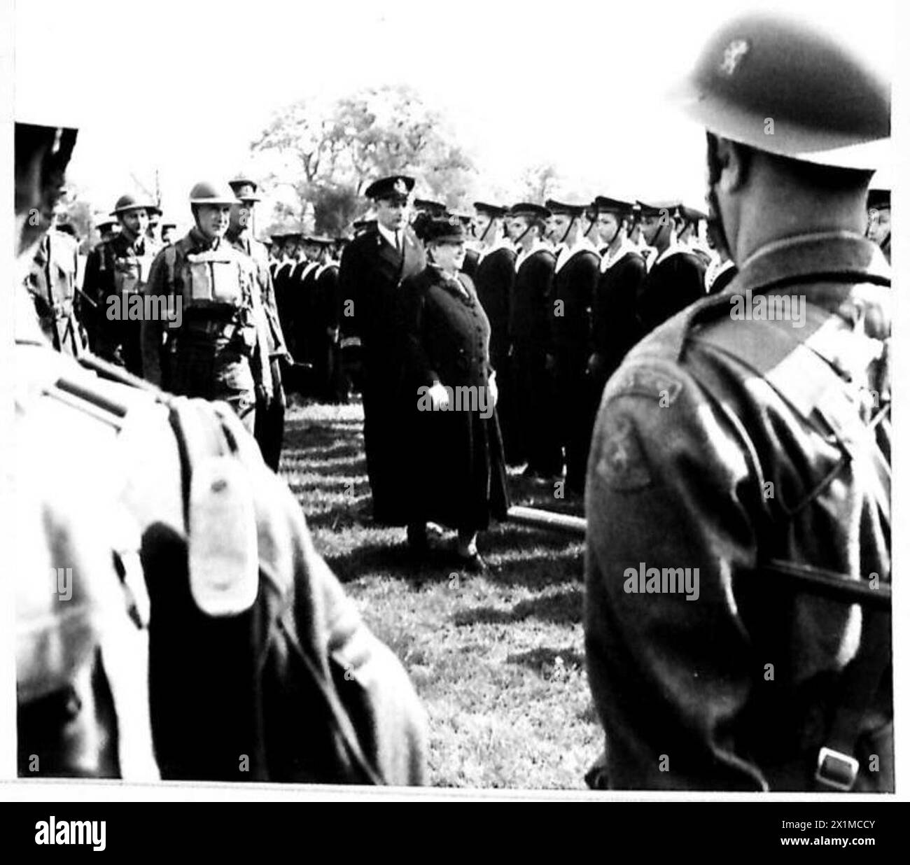 Königin Wilhelmina von Holland inspiziert niederländisch-ostindische Marinestreitkräfte, während sie durch die Reihen von Seeleuten geht, die von britischen Armeepersonal beobachtet werden. Stockfoto