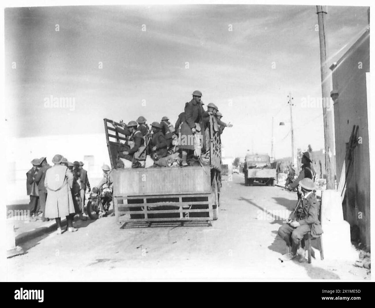 DIE GEFANGENNAHME VON BARDIA - Ein Lastwagen von Truppen, der an die Front durch die Hauptstraße von Bardia, British Army, fährt Stockfoto