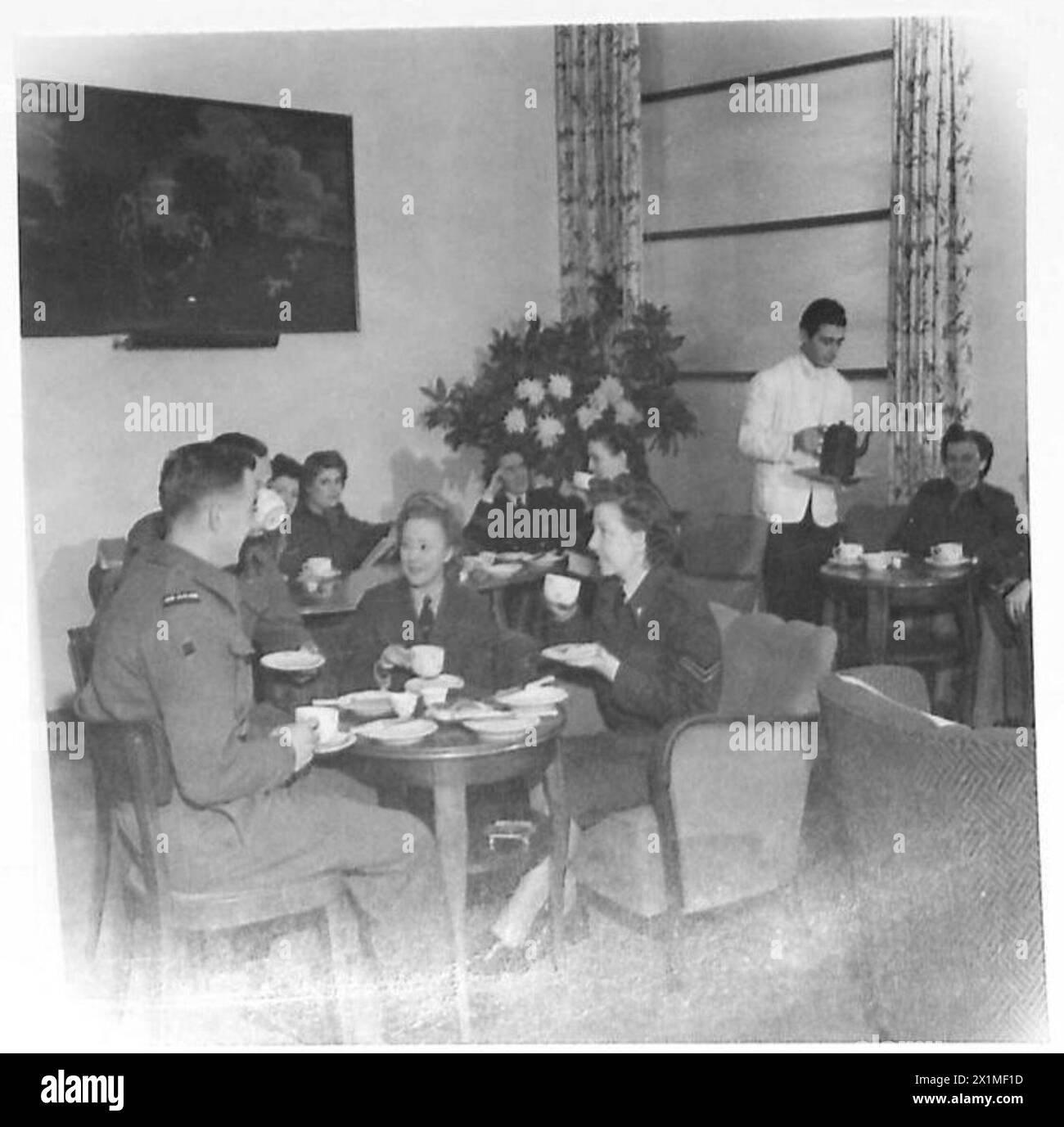 Mitarbeiter der britischen Armee teilen sich Nachmittagstee in der Y.W.C.A. Hotellounge mit zwei neuseeländischen Bekannten, TPR. Ian Ferguson und TPR. Charles Beavan. Stockfoto