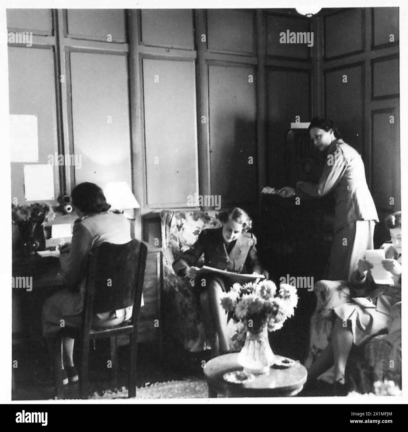 Südafrikanische Dienstfrauen schreiben und lesen in einer ruhigen Lounge auf einem erholsamen Hausboot. Stockfoto