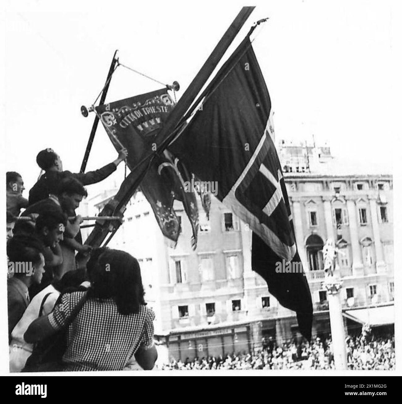 Jugoslawische Truppen verlassen Triest. Die Stadtflagge wird am Rathaus gehisst. Personal der britischen Armee anwesend. Stockfoto