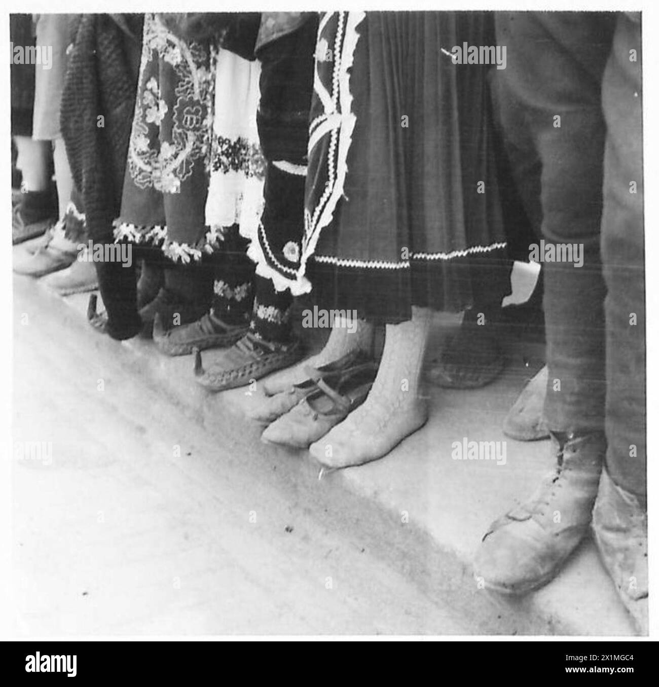 Eine Frau in Jugoslawien zieht ihre Schuhe aus, während sie während der Parade am 27. März wartet. Stockfoto