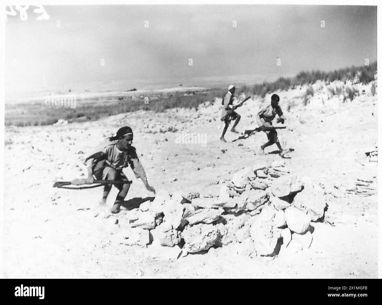Soldaten der Arabischen Legion bewegen sich während Küstenpatrouillen schnell in Verteidigungspositionen entlang der Küste, die unter Aufsicht der britischen Armee operieren. Stockfoto