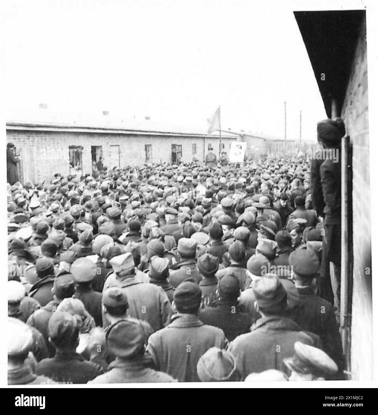 Leutnant Gortshitschnikow spricht am 30. April 1945 in Stalag XB in Sandbostel an. Ein Porträt Stalins wird angezeigt. Stockfoto