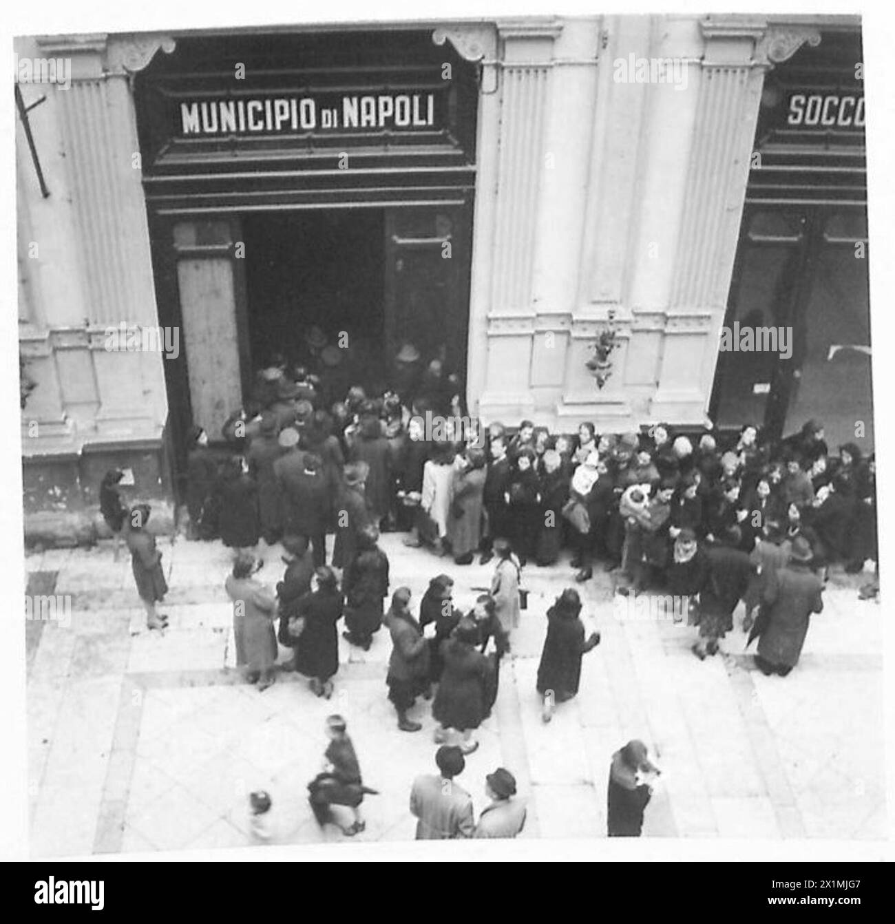 Die Bewohner des von den Alliierten besetzten Neapel stellen sich für öffentliche Hilfsgelder an, was die zivilen Bedingungen während der Operationen der britischen Armee veranschaulicht. Stockfoto
