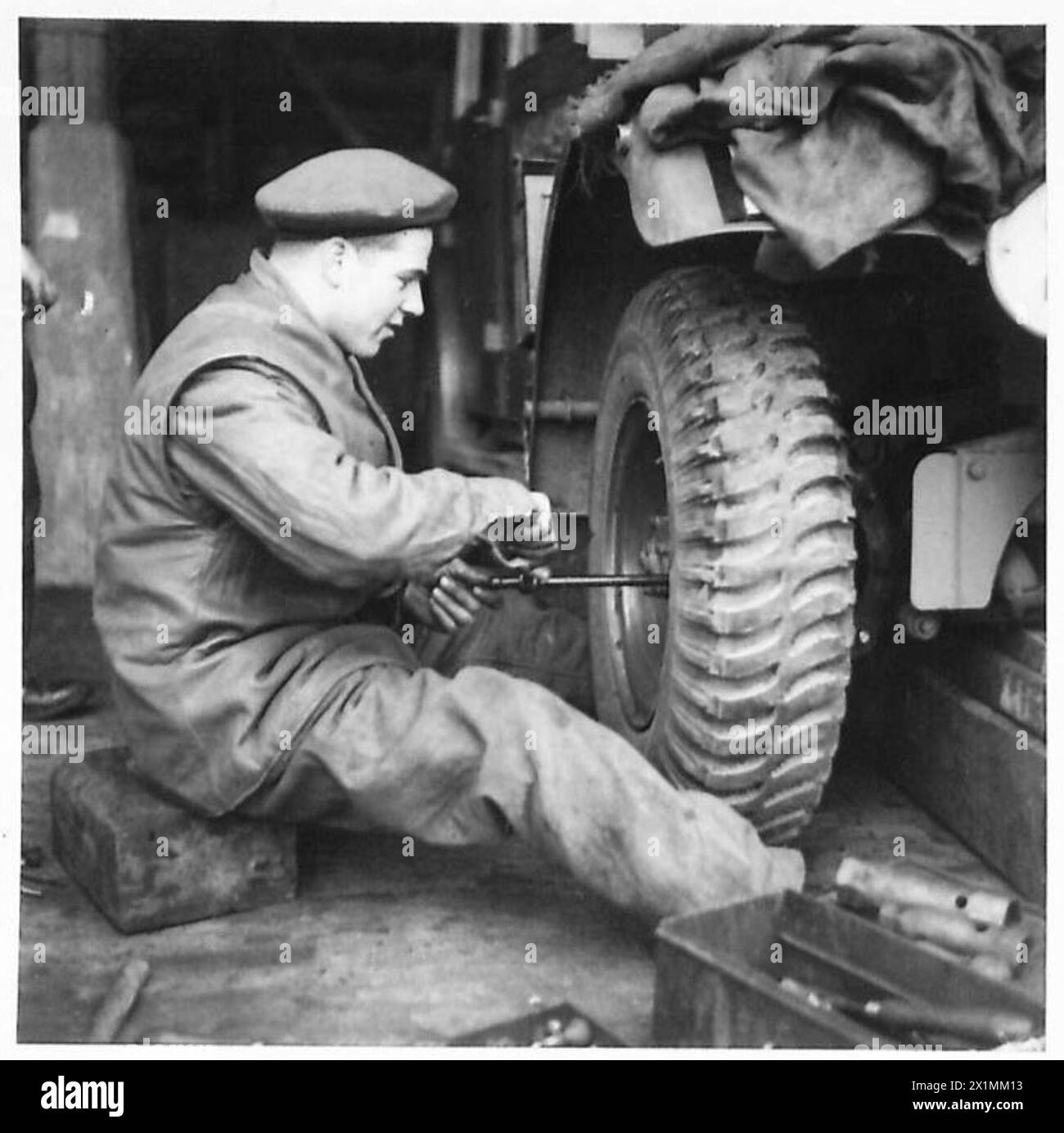 Der Fahrer W.G. Thacker aus Norwich baut ein neues Rad bei der Wartung von Fahrzeugen der britischen Armee, 21st Army Group. Stockfoto