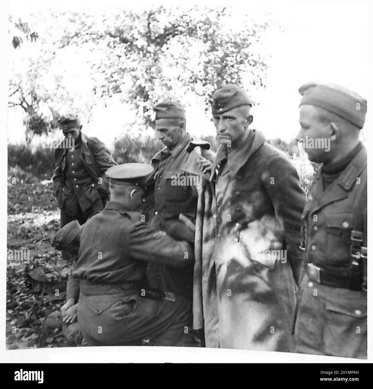 Während des Zweiten Weltkriegs durchsucht ein Wärter deutsche Gefangene in der Nähe des Mount Carmina. Diese Operation war Teil der britischen Bemühungen, strategische Positionen zu sichern und Informationen von gefangengenommenem feindlichem Personal zu sammeln. Stockfoto