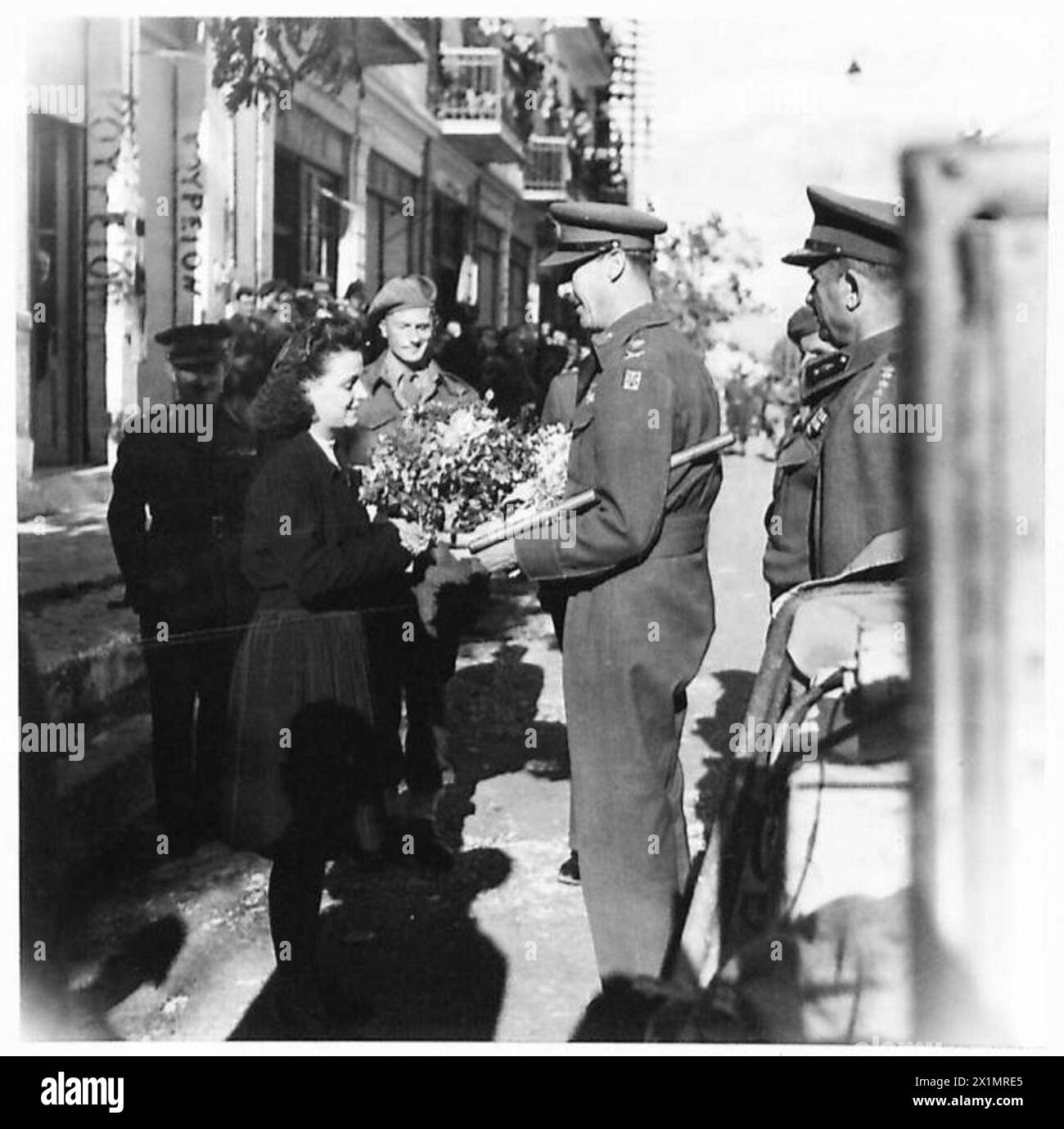 Efterpi Kizou, Vertreter der High School für Mädchen und Tochter des 50. R. R. Dolmetschers, präsentiert dem General einen Blumenstrauß und eine Begrüßungsrede während einer Inspektionsreise in Griechenland, British Army. Stockfoto