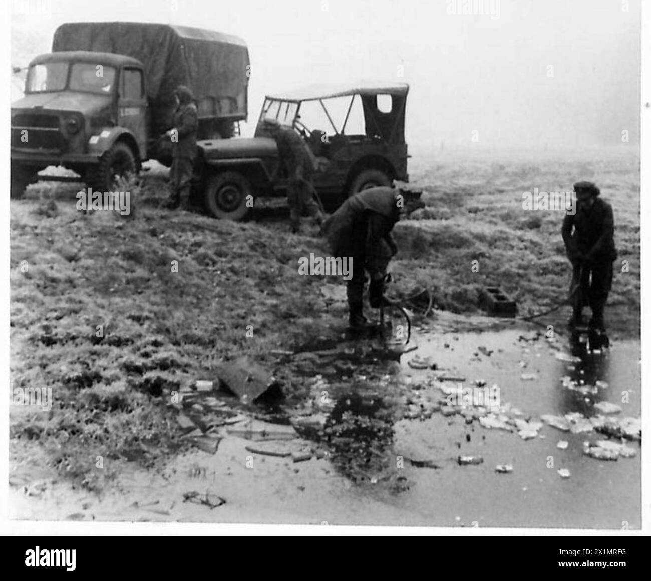 ATS-Mitarbeiter brechen Eis an einem Teich im Depot, um Wasser für die Waschung von Fahrzeugen mit Steigbügelpumpen zu erhalten. Stockfoto