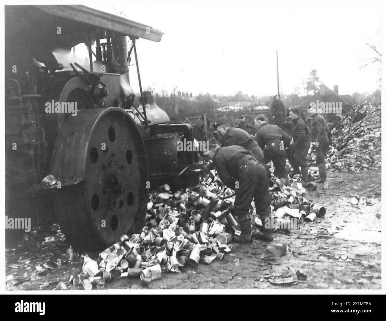 BERGUNGSZENTRUM - Blechdosen werden von einer Dampfwalze zerdrückt, bevor sie geschmolzen werden, British Army Stockfoto