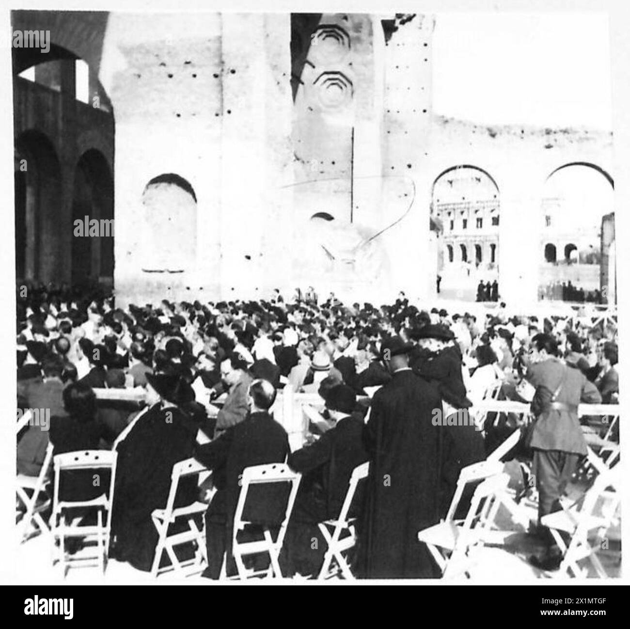 Das Publikum besucht ein Musikkonzert in Rom mit dem im Hintergrund sichtbaren Kolosseum, das von Mitarbeitern der britischen Armee beobachtet wird. Stockfoto