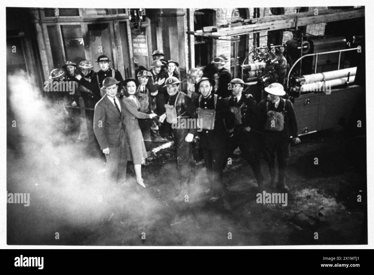 Richard Greene und Valerie Hobson filmen zusammen mit ARP-Schauspielern und Arbeitern eine Szene einer einstürzenden Mauer für „Unpublished Story“ in den Denham Studios, in der der London Blitz von 1940 dargestellt wird. Stockfoto Richard Greene und Valerie Hobson filmen zusammen mit ARP-Schauspielern und Arbeitern eine Szene einer einstürzenden Mauer für „Unpublished Story“ in den Denham Studios, in der der London Blitz von 1940 dargestellt wird. Stockfoto